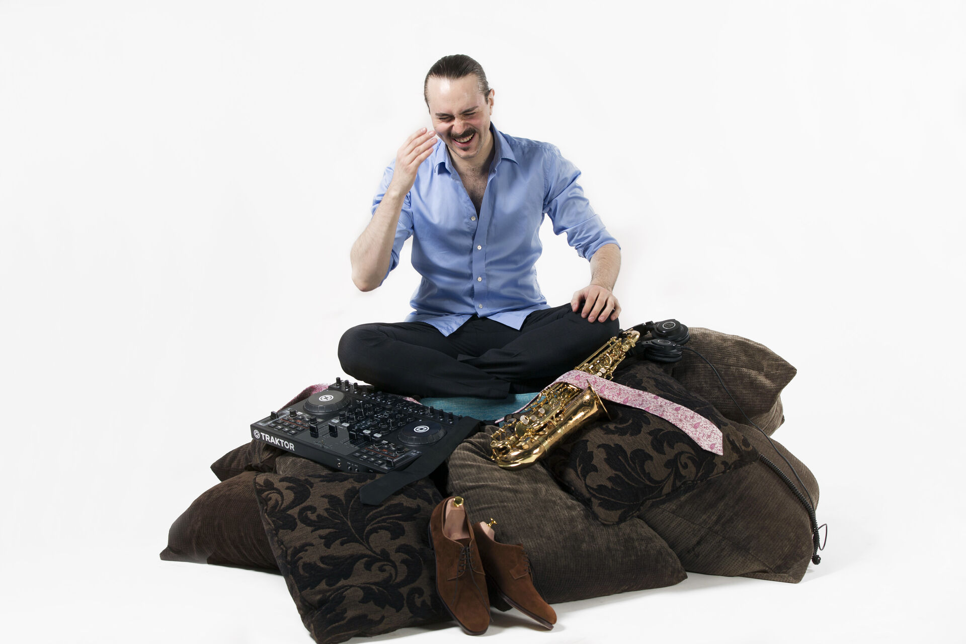 Andreas Ferronato skrattar bland kuddar med sin DJ-mixer och saxofon