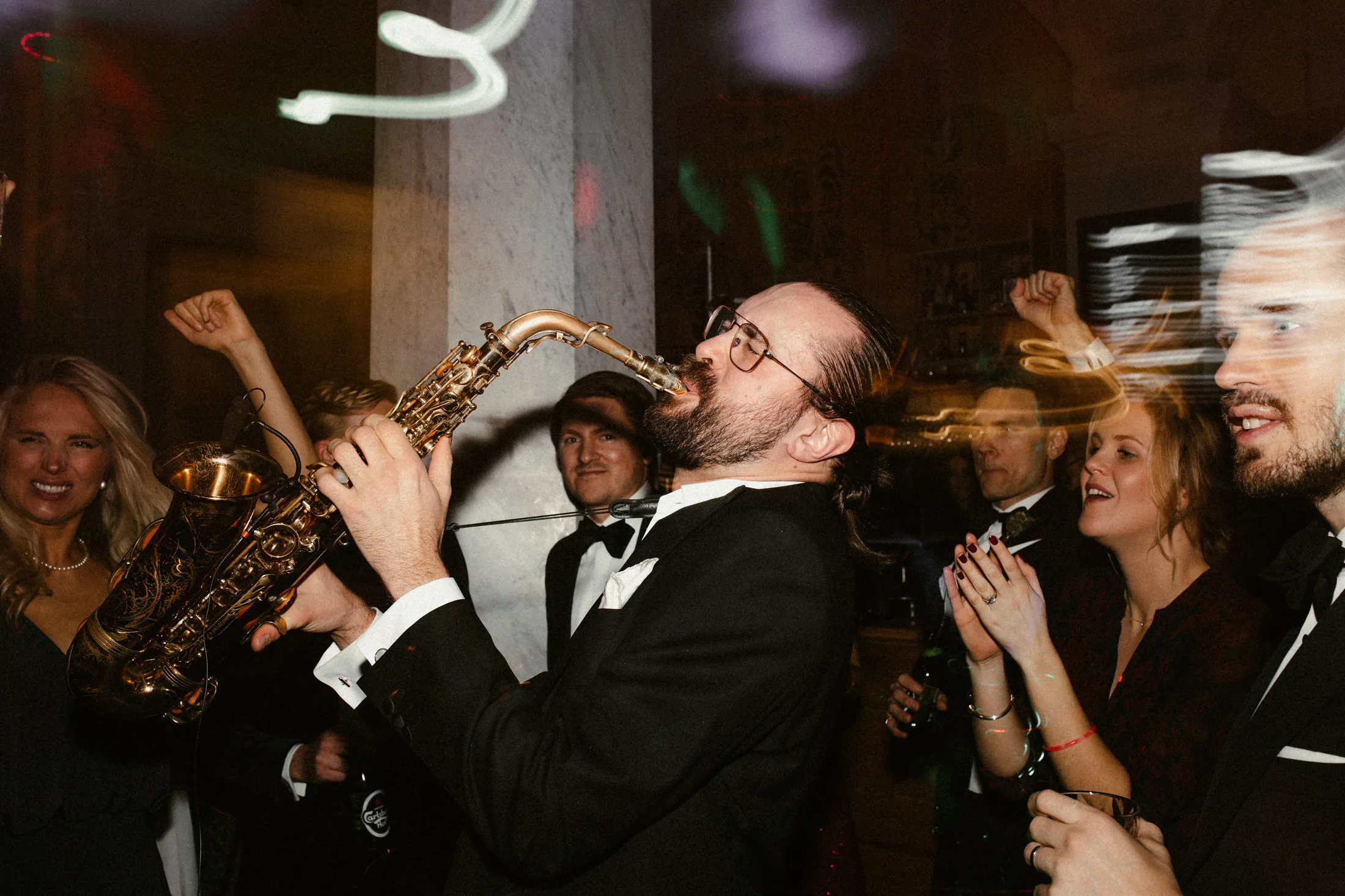 Andreas plays saxophone close to a dancing audience